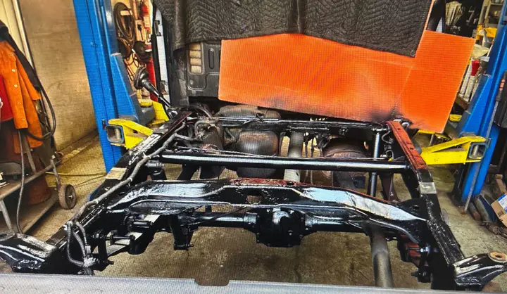 The rebuilt frame painted gloss black and bolted back under the truck