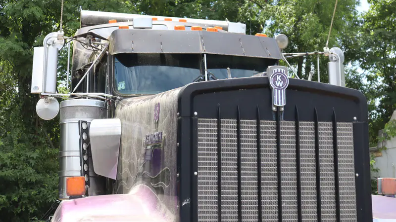 The grille of a Kenworth tractor parked in the yard
