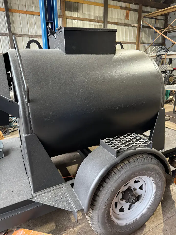 A custom black tank trailer with diamond-plate steps, built in the shop