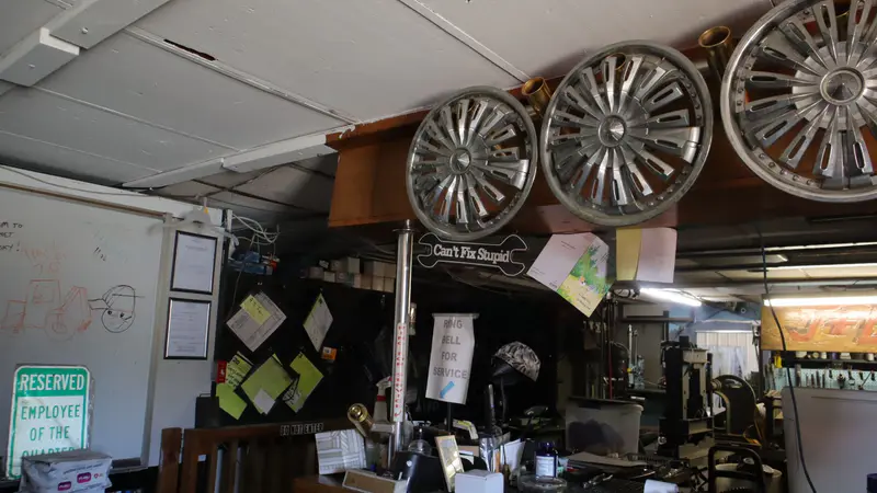 Chrome wheels mounted high on the wall of the shop office